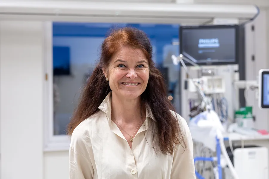 En kvinne som smiler i et rom