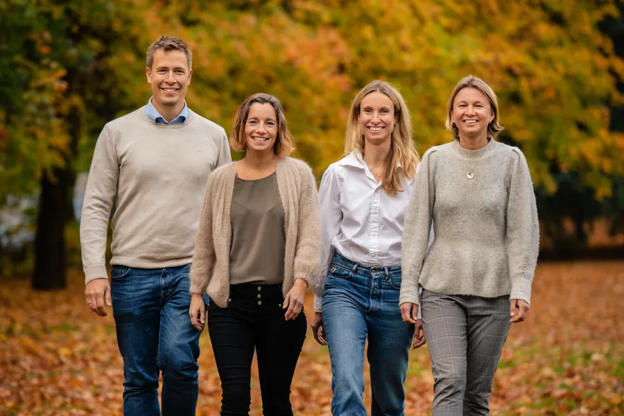 Stipendiaten og de tre veilederne ute, med trær i bakgrunnen