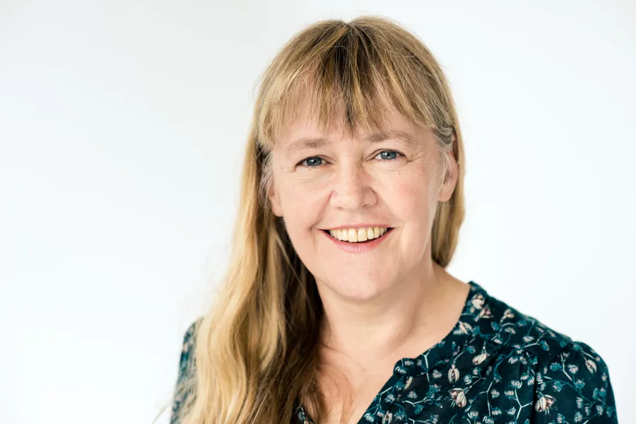 En kvinne som smiler til kameraet