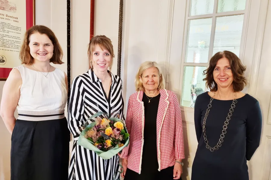 Sissel Urke Olsen mellom sine veiledere, inne i et rom