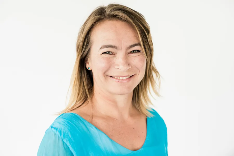 En kvinne som smiler til kameraet